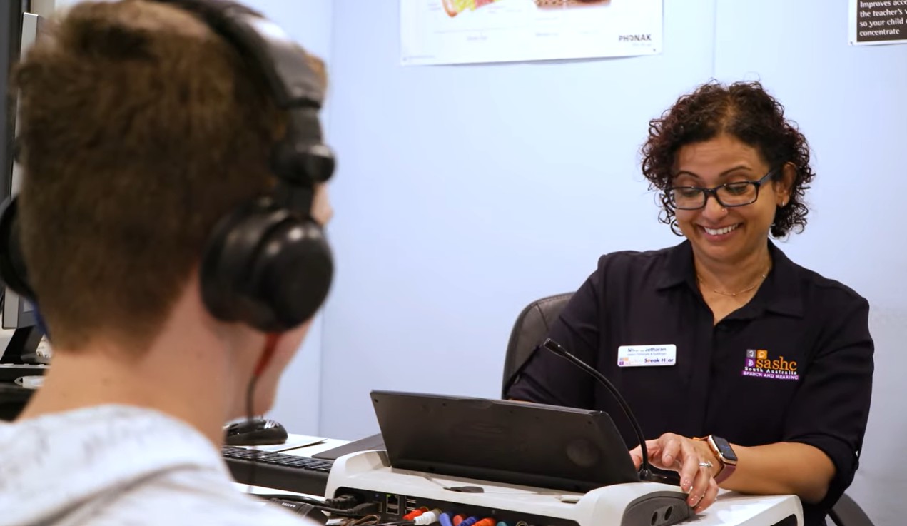 Audiologist conducting a hearing assessment with a young patient